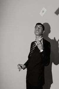 Man playing with cards while standing by wall