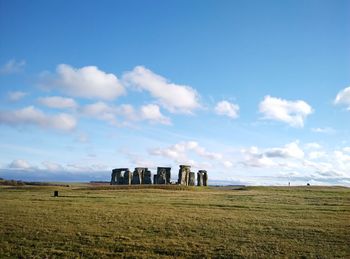 Scenic view of stonehenge on field against sky