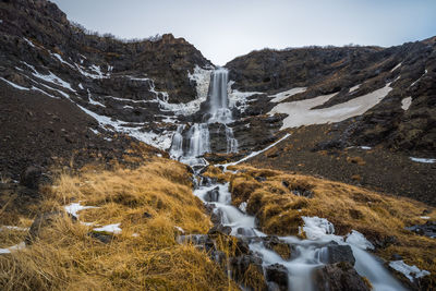 Scenic view of waterfall against sky