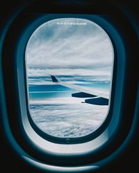 View of cloudy sky seen through airplane window