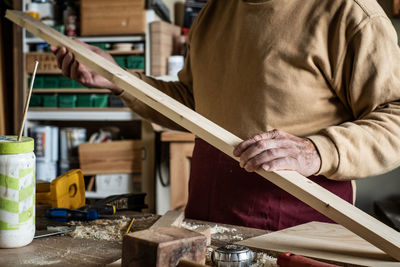 Midsection of carpenter working in workshop