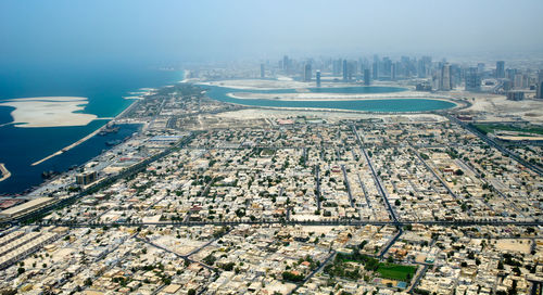 High angle view of buildings by sea against sky