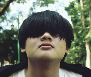 Close-up of young man face covered with hair