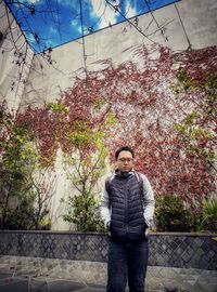 Portrait of young man standing against plants