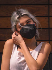 Portrait of a beautiful young woman holding wood