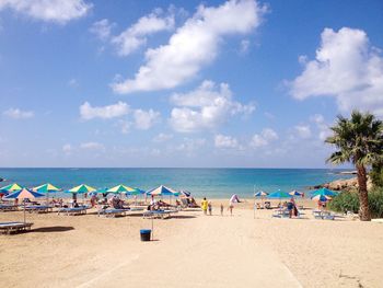 People on beach against blue sky