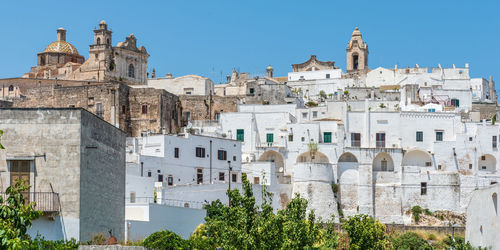 Buildings in city against clear sky