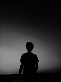 Silhouette man standing against clear sky during sunset