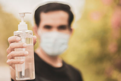 Close-up of man holding sanitizer bottle