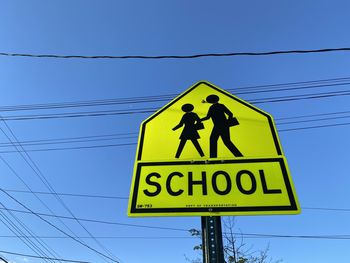 Low angle view of pedestrian crossing road sign against blue sky in mount vernon new york 