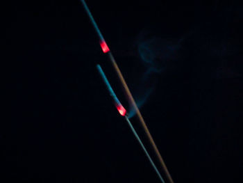 Close-up of illuminated light bulb against black background