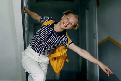 A cheerful teenage girl with a backpack and a folder hurries to school. back to school