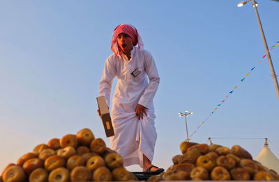 Midsection of man holding fruits against sky