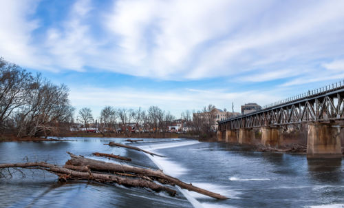 Bridge over river against sky during winter