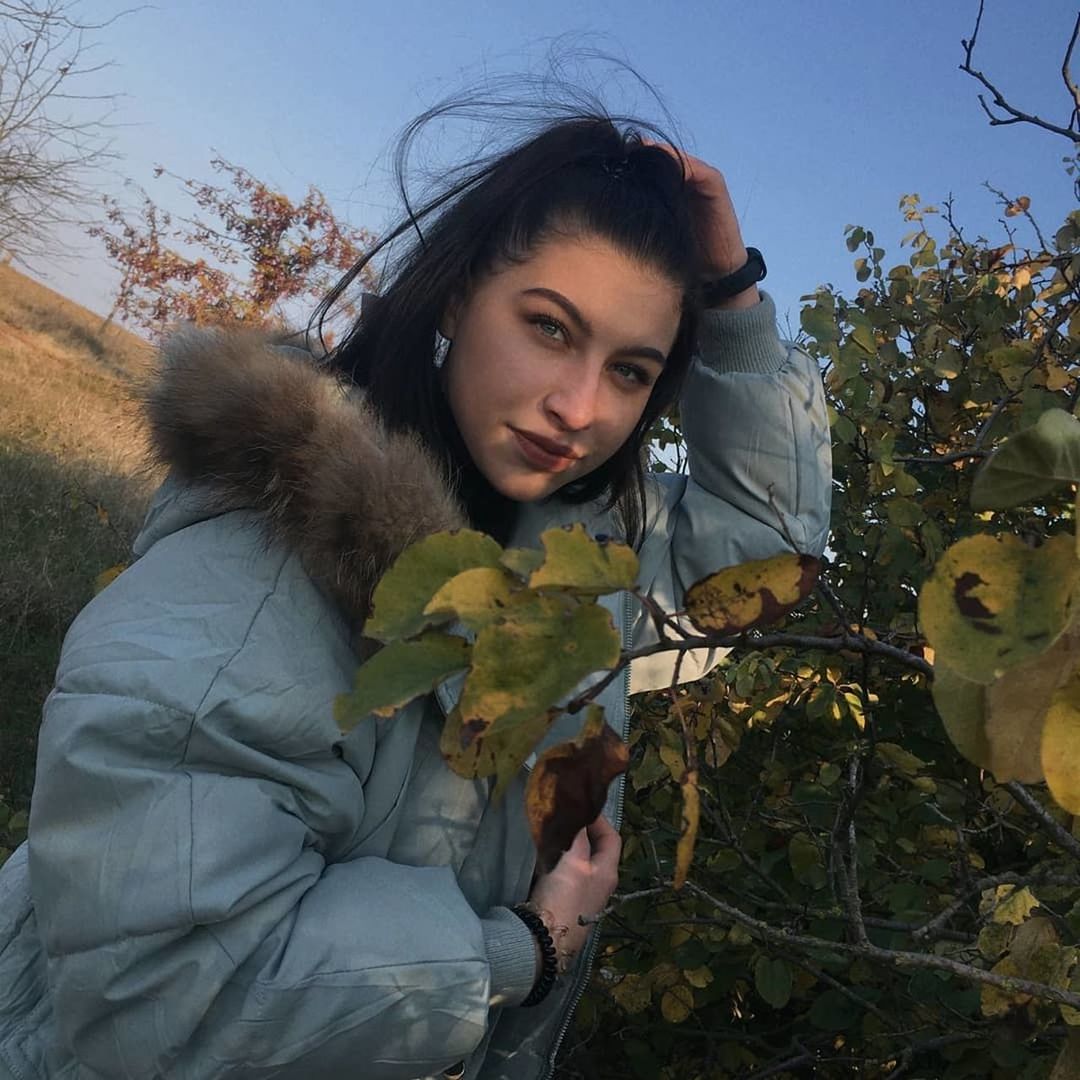 plant, nature, adult, one person, young adult, tree, autumn, portrait, sky, women, leisure activity, flower, looking at camera, clothing, spring, outdoors, winter, leaf, lifestyles, waist up, day, land, looking, person, front view, plant part, human face, holding, brown hair, casual clothing, hairstyle, standing, environment, food, warm clothing, emotion