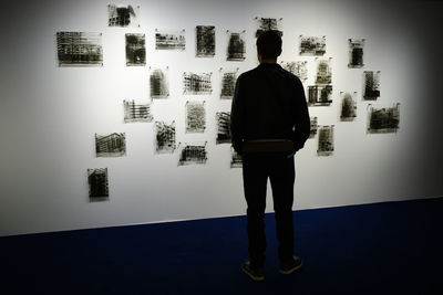 Rear view of man standing in front of building