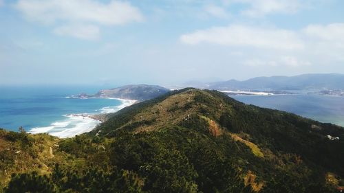 Scenic view of sea and mountains against sky