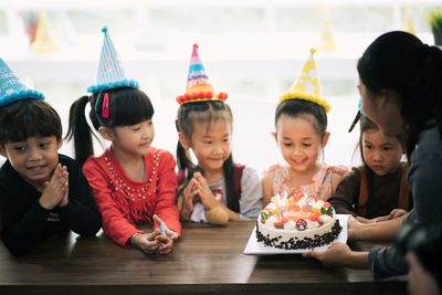 Cute happy friends enjoying birthday party at home