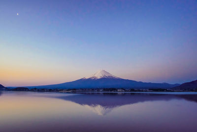 Scenic view of lake against clear blue sky during winter