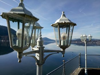 Close-up of street light by sea against sky