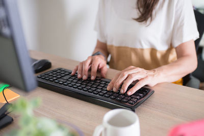 Midsection of man using laptop on table