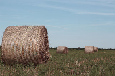 Hay bales on field against sky