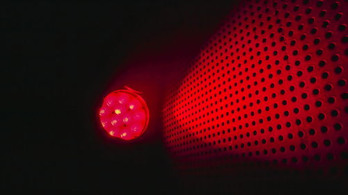 Close-up of illuminated lighting equipment against black background