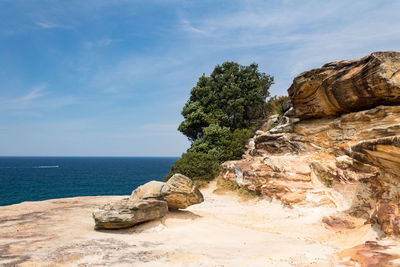 Rock formation on beach against sky