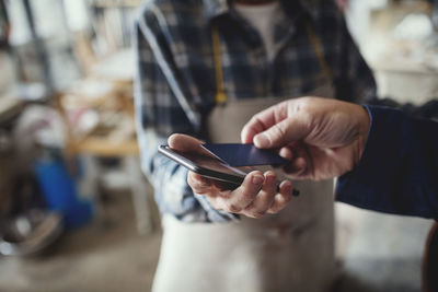 Midsection of person using mobile phone