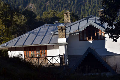 Exterior of house by buildings against sky