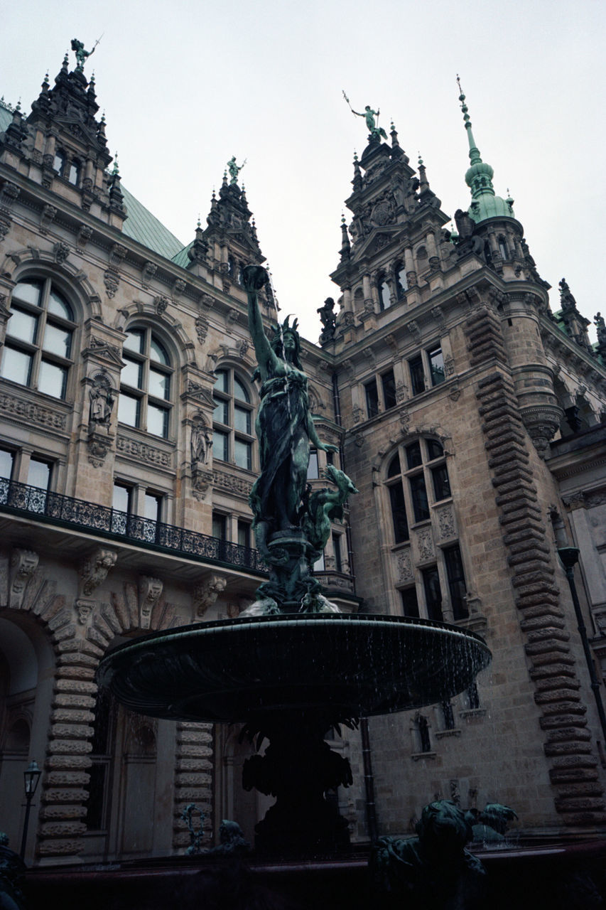 LOW ANGLE VIEW OF STATUE AGAINST BUILDINGS IN CITY