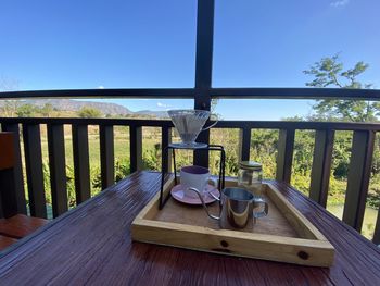 Bicycle on table by sea against sky seen through glass window