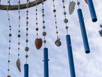 Low angle view of lighting equipment hanging against sky