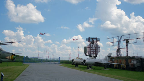 Airplane flying over airport runway against sky