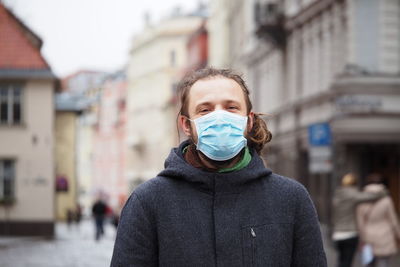 Portrait of man standing on street in city