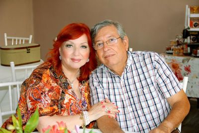 Portrait of couple sitting on chair at home