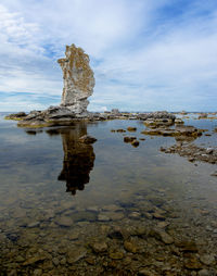 Rock formation in sea against sky