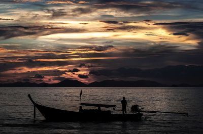 Boat sailing in sea at sunset
