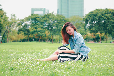 Young woman sitting on grassy field