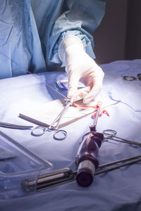 Midsection of surgeon holding medical equipment at hospital