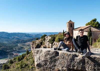 Father and son spending time together on a sunny day on a cliff overlooking the reservoir