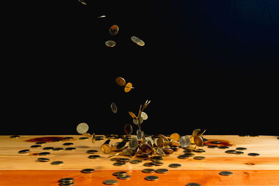 Close-up of flower in vase on table against black background