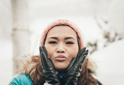 Portrait of young woman in hat during winter