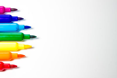 High angle view of multi colored pencils against white background