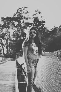 Portrait of smiling young woman standing against trees