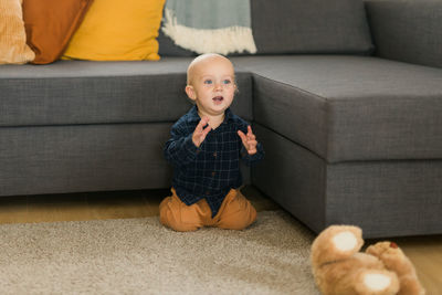 Portrait of boy sitting on sofa at home