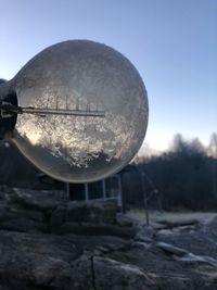 Close-up of crystal ball on field against clear sky