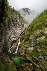 Scenic view of waterfall in mountains