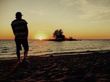 Silhouette of people on beach at sunset