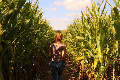 Rear view of woman standing in field